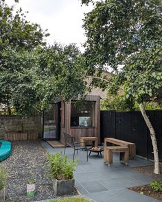 an outdoor patio with wooden tables and chairs next to a pool in the back yard