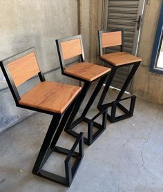 three chairs sitting on top of each other in front of a wall with a window