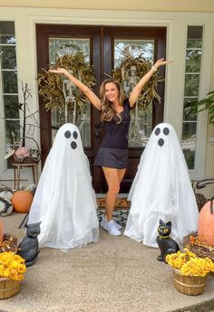 a woman standing in front of a door decorated with fake ghost heads and pumpkins