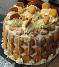 a cake with white icing and orange decorations on it's top sitting on a glass table