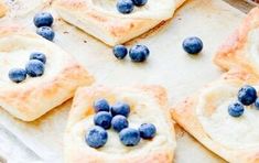 blueberries and cream puff pastry on a baking sheet