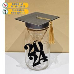 a graduation cap on top of a mason jar with the number twenty four in it