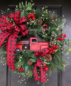 a christmas wreath with a red truck and pine cones