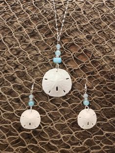 "Gorgeous natural sand dollar necklace with matching earring set. The sand dollars are real and are in their natural condition, and accented with beads in varying shades blue. This would be a gorgeous set for a beach wedding for a bride. bridesmaids, or just a gift for the beach lover in your life. The pendant (approximately 1.5\" across) is set on an 18\", anti-tarnish stainless steel chain that sparkles in the light. Multiple sizes of chain are available. The set is also available in stainless Crafts To Do With Sand Dollars, Nickel Free Ocean-inspired Pendant Jewelry, Nickel-free Ocean-inspired Pendant Jewelry, Nickel-free Ocean-inspired Round Pendant Jewelry, Adjustable Ocean-inspired Round Pendant Jewelry, Handmade Round Pendant Jewelry For Beach, Handmade Ocean-inspired Round Pendant Jewelry, Ocean-inspired Silver Jewelry With Matching Earrings, Ocean-inspired Turquoise Sterling Silver Jewelry