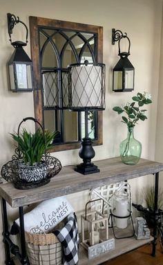 a table with some plants on top of it and other items in front of the mirror