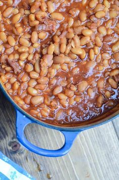 a blue pot filled with beans on top of a wooden table