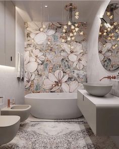 a white bath tub sitting next to two sinks in a bathroom under mirrors and lights