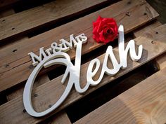 a wooden sign that says mersey's cleash with a red rose on top