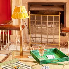 a green tray sitting on top of a glass table next to a lamp and chair