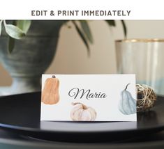 a place card sitting on top of a black plate next to a potted plant