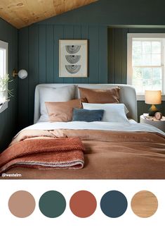 a bedroom with green walls and wood paneled ceiling, white bedding, brown blanket, orange throw pillows