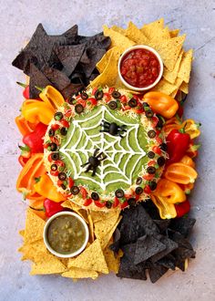 a platter with chips, salsa and guacamole on it next to tortilla chips