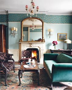 a living room filled with furniture and a fire place next to a mirror on the wall