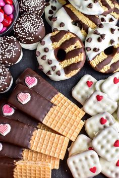 valentine's day cookies and waffles are arranged on a table with candy