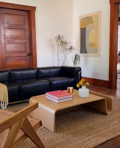 a living room with black leather couch and coffee table