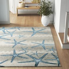 a blue and white area rug with starfishs on it in front of stairs