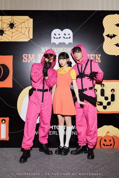 three people in pink costumes standing next to each other