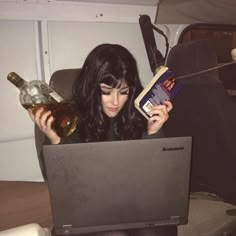 a woman sitting on a couch with a laptop and bottles in front of her face