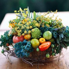 a basket filled with fruits and vegetables on top of a wooden table in front of trees