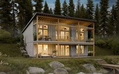 a small house is lit up at night in the woods with rocks and trees surrounding it