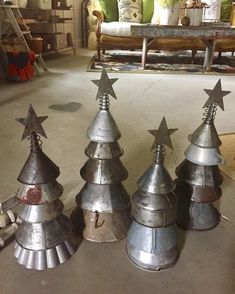 three metal christmas trees sitting on top of a floor