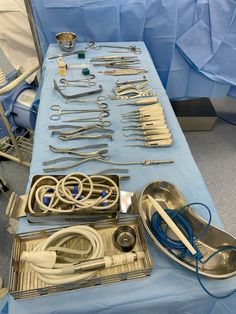 medical equipment is laid out on a table in an operating room with blue cloths