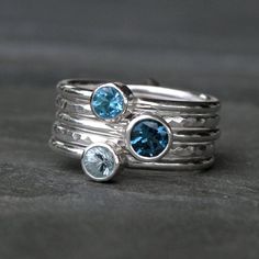 "Deep Sea Stacking Rings Set of five sterling silver stacking rings in beautiful blues. Three smooth ring bands are set with a gorgeous variety of blue faceted gemstones. 2 plain ring bands are given a hammered texture & a bright polished finish. Wear them all together, mix and match, or wear one elegant ring at time. 5mm London Blue Topaz 4mm Aquamarine 4mm Swiss Blue Topaz and two hammered stacking rings. Each ring is 1/16th of an inch. Together the stack is just over one quarter inch wide Topaz Stackable Ring, Aquamarine Stacking Ring, Silver Labrador, Sterling Silver Stacking Rings, Stacking Ring Set, Silver Stacking Rings, Jewellery Ideas, Epilator, Swiss Blue Topaz