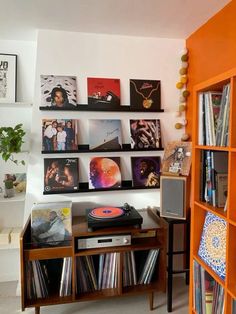 an orange book shelf filled with vinyl records