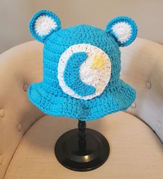 a blue crocheted hat with ears on top of a chair