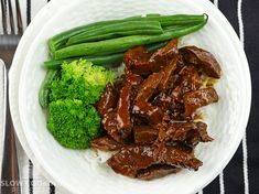 a white plate topped with meat and green beans