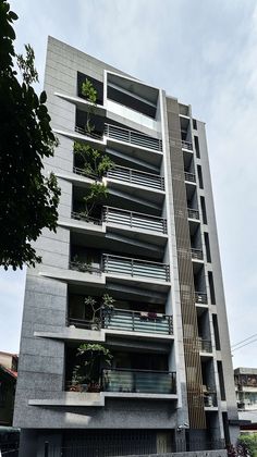 an apartment building with balconies and plants growing on the balconyes in front of it