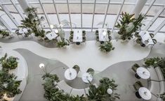 an overhead view of a restaurant with tables and chairs covered in greenery on the floor