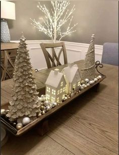 a wooden table topped with white christmas trees and decorations on top of it's tray