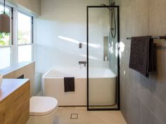 a bathroom with a toilet, sink and bathtub next to a window in it