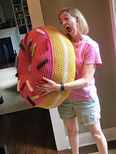 a woman holding a large stuffed animal in front of her face and making a funny face