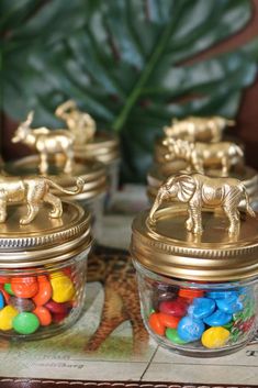 small glass jars filled with candy and gold elephant figurines on top of a table