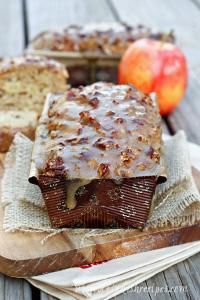 there is a piece of cake that is on the table next to an apple and bread