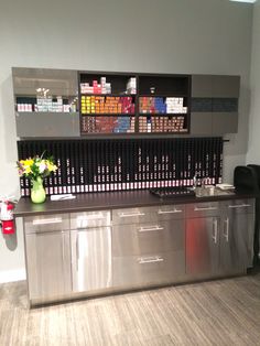 a kitchen area with stainless steel cabinets and flowers on the counter top in front of it