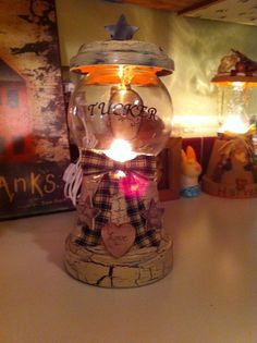 a glass jar with a candle inside on a table