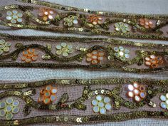 three pieces of fabric with flowers and sequins on them