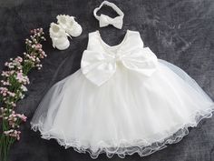 - A beautiful dress for your little princess + headband + shoes - Everything is made with love, simply breathtaking and graceful - Condition: New - Material: 100% polyester decorated with an elegant bow **- Available sizes - Gr. 56 - Gr. 62 - Gr. 68 - Gr. 74 - Gr. 80 - Gr. 86 - Gr. 92 - Gr. 98 - If you need a different size, just write to us - Please specify size **Please note - Sizes: +/-2 cm tolerance due to manual measurement. - The colors in the illustrations are never 100% like the picture. Summer Princess Baptism Dress With Bow, Cream Princess Dress For Summer Wedding, Cream Princess Dress For Baptism In Summer, Summer Cream Princess Dress For Baptism, Elegant Baptism Dress With Bow For Party, Elegant First Communion Dress For Summer, Summer Baptism Cream Princess Dress, White Bow Dress For First Birthday, White Elegant Baptism Dress For First Birthday