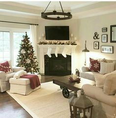 a living room filled with furniture and a christmas tree in front of a fire place