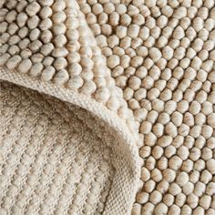 the textured rug is made from wool and has many small balls on it's surface