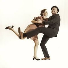 a man and woman are dancing together on a white background with one holding the other's leg