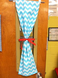 the door is decorated with blue and white chevrons, red ribbon on it