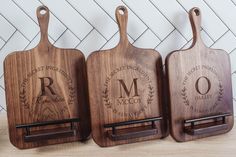 three wooden cutting boards with monogrammed names on them, each holding a knife holder