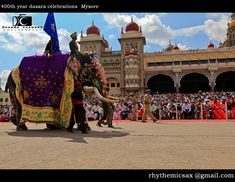 an elephant dressed in colorful clothing with people watching