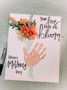 a handprinted card with flowers on it that says, your love helps me bloom happy mother's day