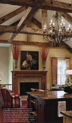 a living room filled with furniture and a chandelier hanging from the ceiling next to a fire place