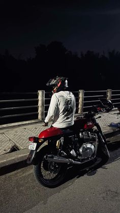 a man riding on the back of a red motorcycle